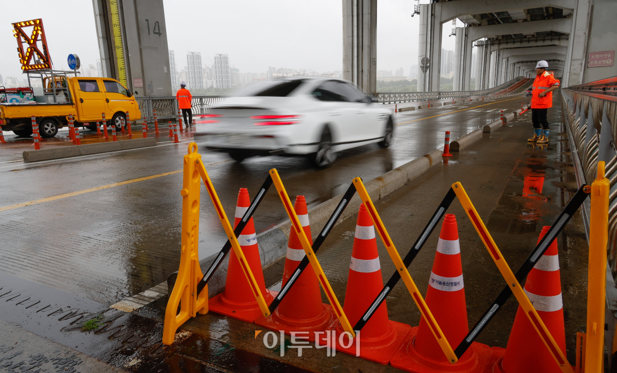 ▲서울 전역에 호우경보가 내려진 18일 서울 잠수교에서 관계자들이 보행자 통로를 통제하고 있다. 조현호 기자 hyunho@