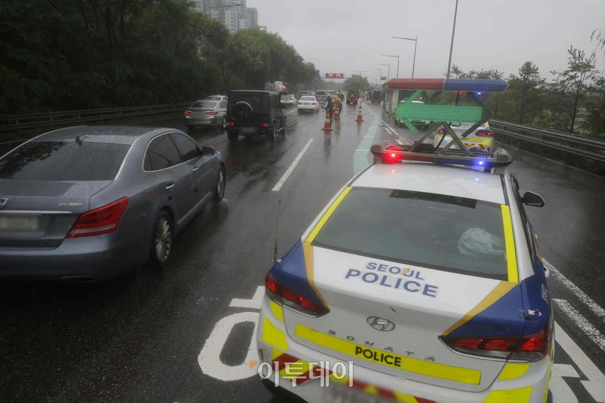 ▲서울 전역에 호우 경보가 내려진 18일 서울 올림픽대로에서 관계자들이 반포한강공원 방향의 차량 통행을 통제하고 있다. 조현호 기자 hyunho@