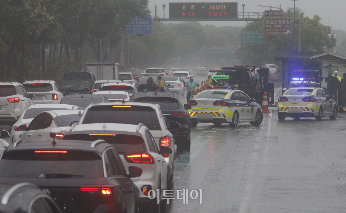 ▲서울 전역에 호우 경보가 내려진 18일 서울 올림픽대로에서 관계자들이 반포한강공원 방향의 차량 통행을 통제하고 있다. 조현호 기자 hyunho@