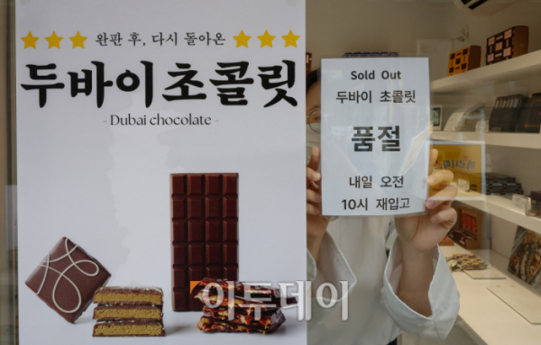 ▲소셜네트워크서비스(SNS)에서 인기몰이 중인 두바이 초콜릿이 품귀 대란을 겪고 있는 가운데 9일 서울의 한 두바이 초콜릿 판매점 입구에서 직원이 품절 안내문을 붙이고 있다. 두바이 초콜릿은 한 아랍에미리트 인플루언서가 초콜릿 먹는 영상을 SNS에 올리면서 전세계적인 인기를 끌고 있다. 조현호 기자 hyunho@