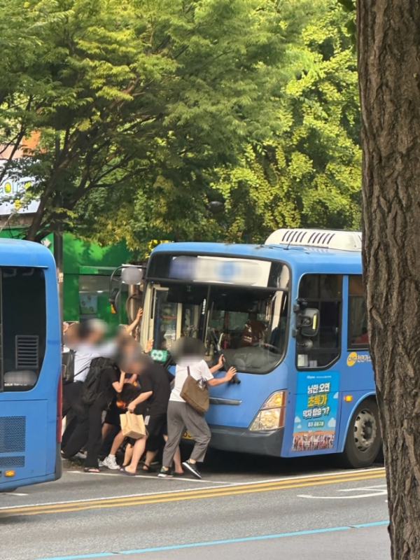▲11일 시민들이 여성을 구조하기 위해 버스를 들어올리고 있다.  (사진=시청자 제공)