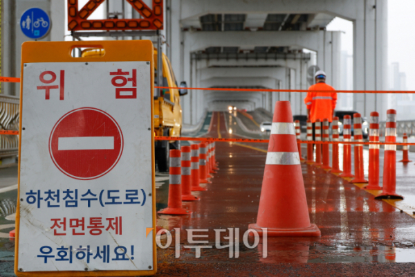 ▲서울 전역에 호우경보가 내려진 18일 서울 잠수교에서 관계자들이 보행자 통로를 통제하고 있다. 조현호 기자 hyunho@