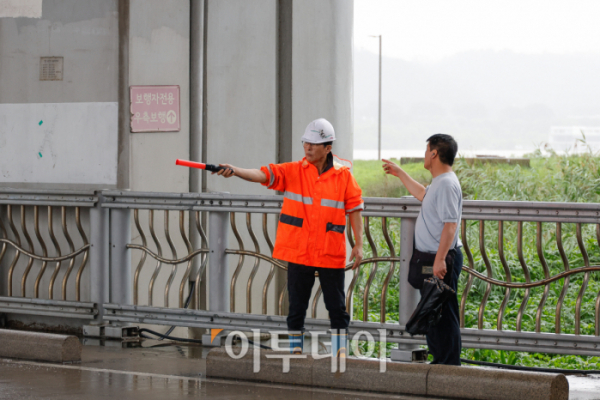 ▲서울 전역에 호우경보가 내려진 18일 서울 잠수교에서 관계자들이 보행자 통로를 통제하고 있다. 조현호 기자 hyunho@