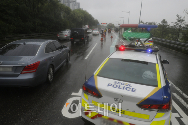 ▲서울 전역에 호우 경보가 내려진 18일 서울 올림픽대로에서 관계자들이 반포한강공원 방향의 차량 통행을 통제하고 있다. 조현호 기자 hyunho@