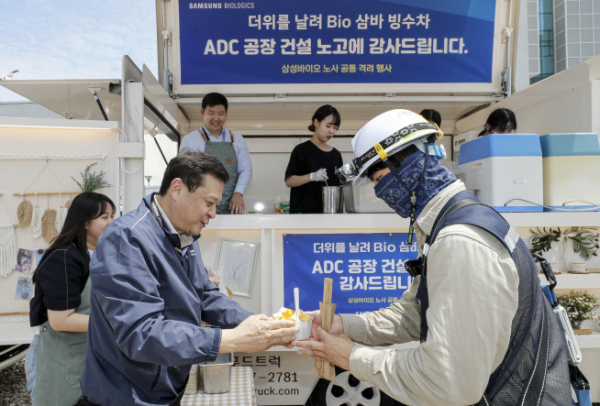 ▲삼성바이오로직스 노사는 19일 인천 송도에 위치한 ADC 공장 건설 현장에서 협력사 기술인 900여명을 대상으로 빙수와 츄러스를 제공하는 상생협력 행사를 진행했다. 이규호 삼성바이오로직스 피플센터 센터장(사진 가운데)이 협력사 기술인에게 빙수를 전달하고 있다.  (사진제공=삼성바이오로직스)