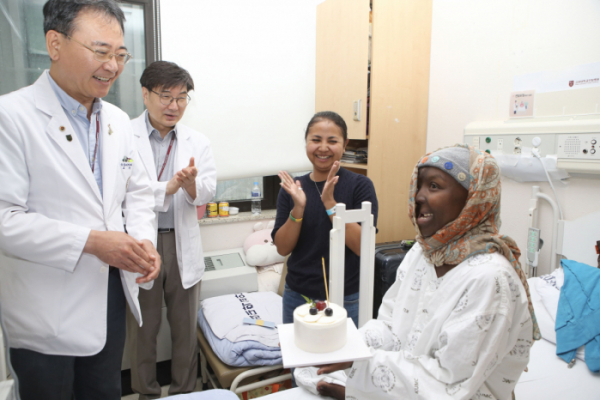 ▲에프라지가 퇴원 축하 기념 케이크를 받고 있다. (사진제공=고려대 의료원)