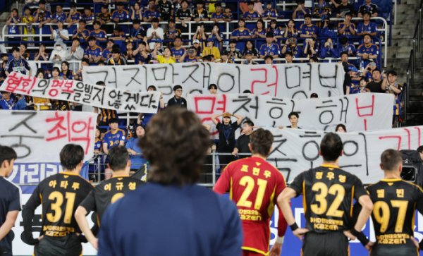 ▲지난달 10일 울산 문수축구경기장에서 축구 국가대표팀 감독으로 내정된 울산 HD 홍명보 감독이 광주 FC와의 경기 후 자신을 비판하는 걸개가 내걸린 서포터스석을 바라보고 있다. (연합뉴스)