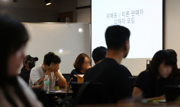 ▲티몬·위메프 판매대금 정산 지연 사태가 이어지는 가운데 28일 오후 서울 강남구 역삼동의 한 빌딩에서 열린 티몬.위메프 피해 입점 판매자(셀러) 대책회의에 참석한 한 판매자가 얼굴을 감싸고 있다. (연합뉴스)