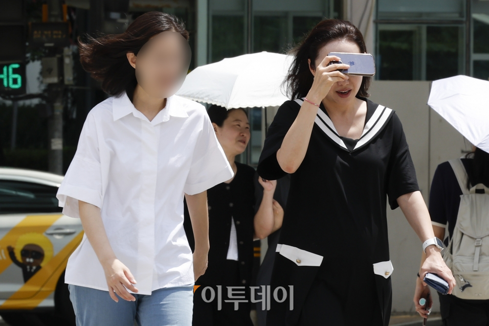 ▲ 서울 영등포구 여의도역 일대에서 한 시민이 핸드폰으로 더위를 피하며 발걸음을 옮기고 있다. 조현호 기자 hyunho@