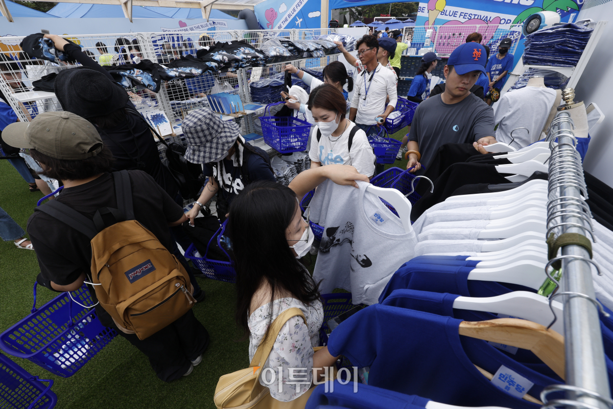 ▲18일 서울 송파구 올림픽공원 한얼광장에서 열린 더불어민주당 당원축제 블루페스티벌에서 참석자들이 굿즈를 살펴보고 있다. 조현호 기자 hyunho@