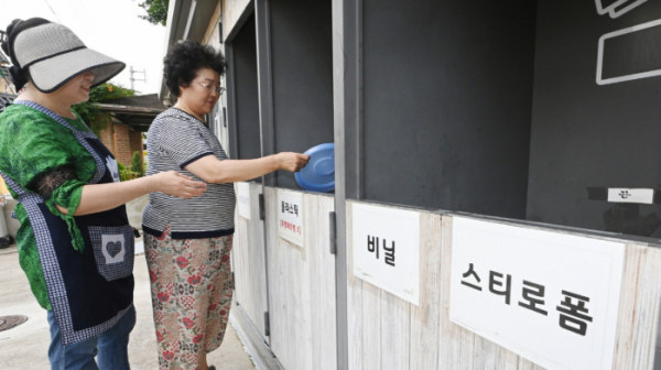 ▲수원시 권선구 세류2동 자원순환역에 배치된 관리자가 주민에게 분리배출을 지도하고 있다. (수원특례시)