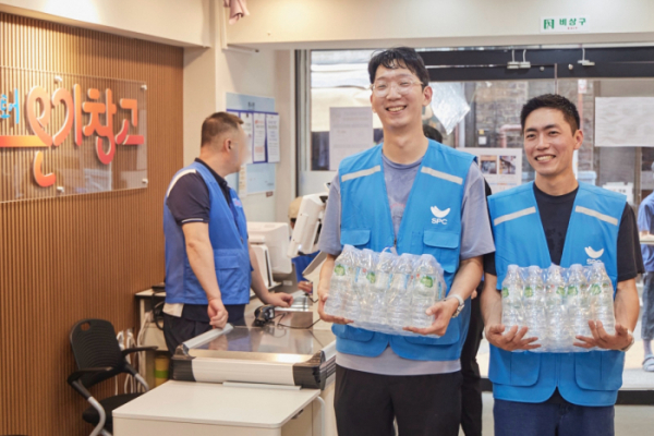 ▲12일 서울 용산구 서울역쪽방상담소가 운영하는 나눔스토어 ‘온기창고’에서 SPC그룹 임직원들이 생수를 전달하고 물품 정리 봉사활동을 진행하고 있다. (사진제공=SPC)