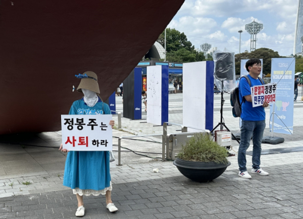 ▲18일 서울 송파구 올림픽공원 한얼광장에서 열린 더불어민주당 당원축제 블루페스티벌에서 정봉주 최고위원 후보의 사퇴를 요구하는 당원들이 팻말을 들고 서 있다. (서이원 기자 iwonseo96@)