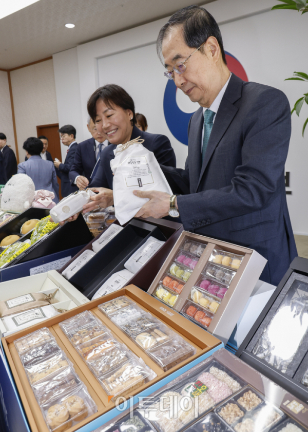 ▲한덕수 국무총리와 송미령 농림축산식품부 장관이 3일 서울 종로구 정부서울청사에서 열린 농수산식품 소비촉진 행사에서 추석 민생 선물세트를 살펴보고 있다. 이날 한 총리와 국무위원들은 국가최고 회의기구인 국무회의장을 민생 프로모션장으로 활용해 쌀·한우·전복 등 추석 민생 선물세트를 홍보했다. 조현호 기자 hyunho@