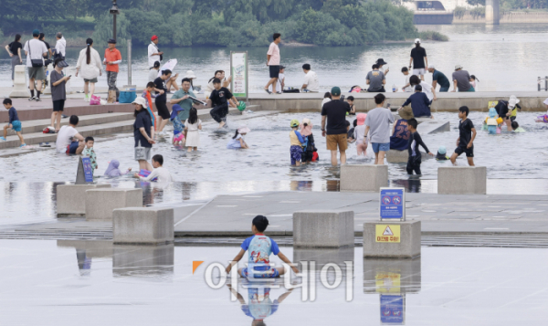 ▲서울 낮 최고기온이 32도까지 오르는 등 늦더위가 기승을 부린 8일 서울 영등포구 여의도물빛광장을 찾은 시민들이 물놀이를 하며 더위를 식히고 있다. 조현호 기자 hyunho@