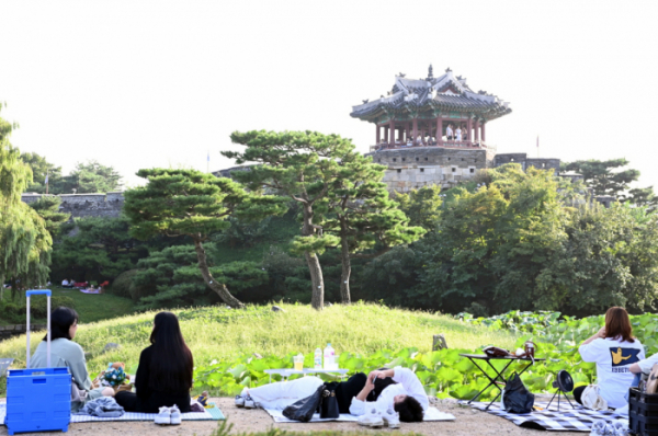 ▲시민들이 수원화성 방화수류정이 보이는 용연에서 가을 피크닉을 즐기고 있다.