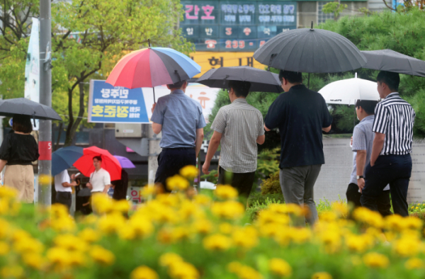 ▲20일 광주 북구청 앞에서 시민들이 내리는 비에 우산을 쓰고 이동하고 있다. (연합뉴스)