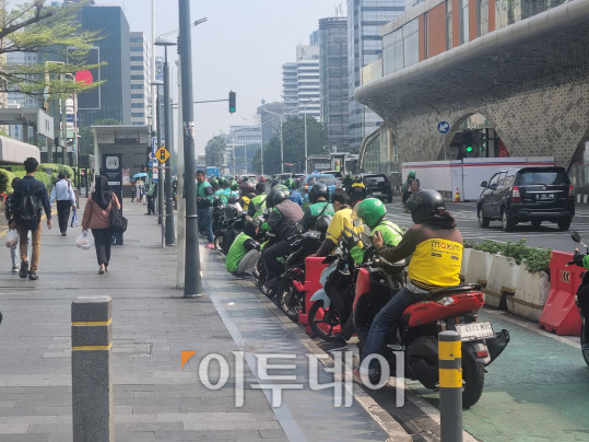 ▲인도네시아 중앙 자카르타의 한 대로변 모습. 버스 정류장과 지하철 역 근처 길가에 일렬로 정차한 오토바이 택시 기사들이 핸드폰으로 휴식을 취하거나 고객을 찾고 있다. (유하영 기자 haha@)