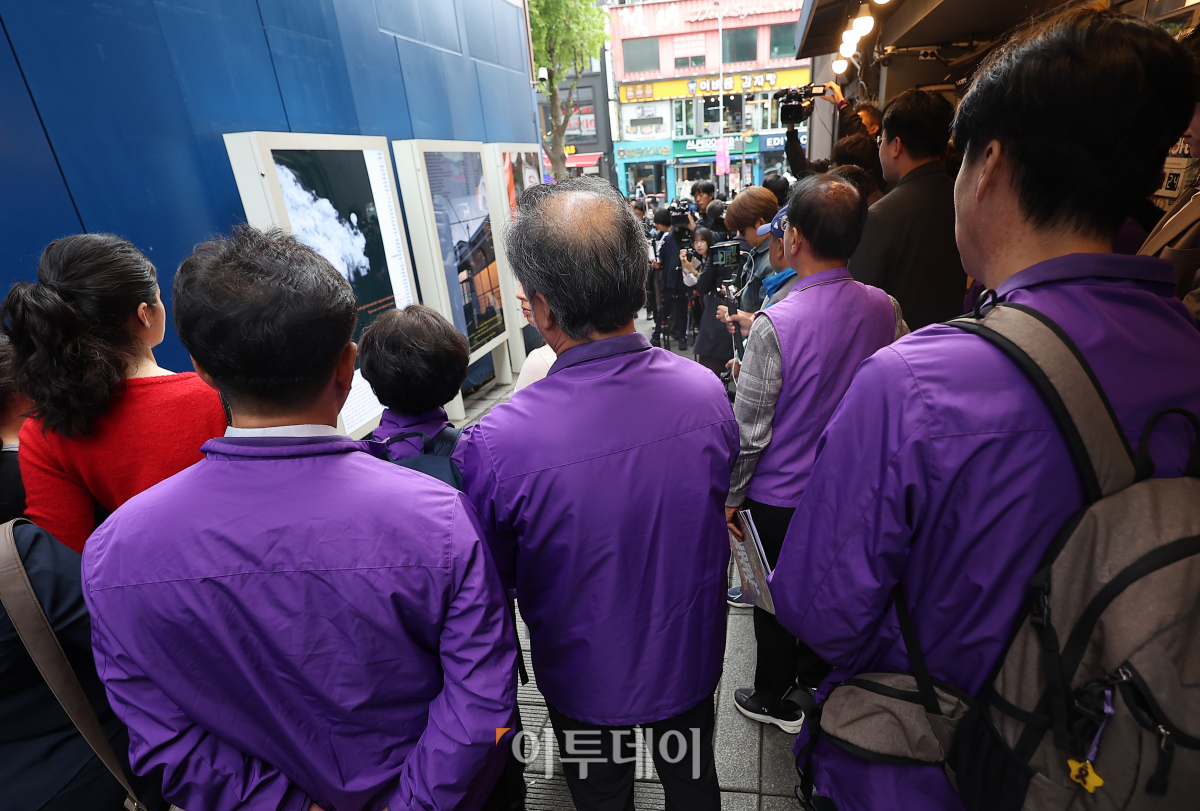 ▲28일 서울 용산구 이태원 참사 골목 '10.29 기억과 안전의길'에서 열린 새로운 10·29 이태원 참사 기억과 안전의 길 2주기 빌보드 개막식에서 유가족들이 권은비 작가의 작품 소개를 듣고 있다. 조현호 기자 hyunho@