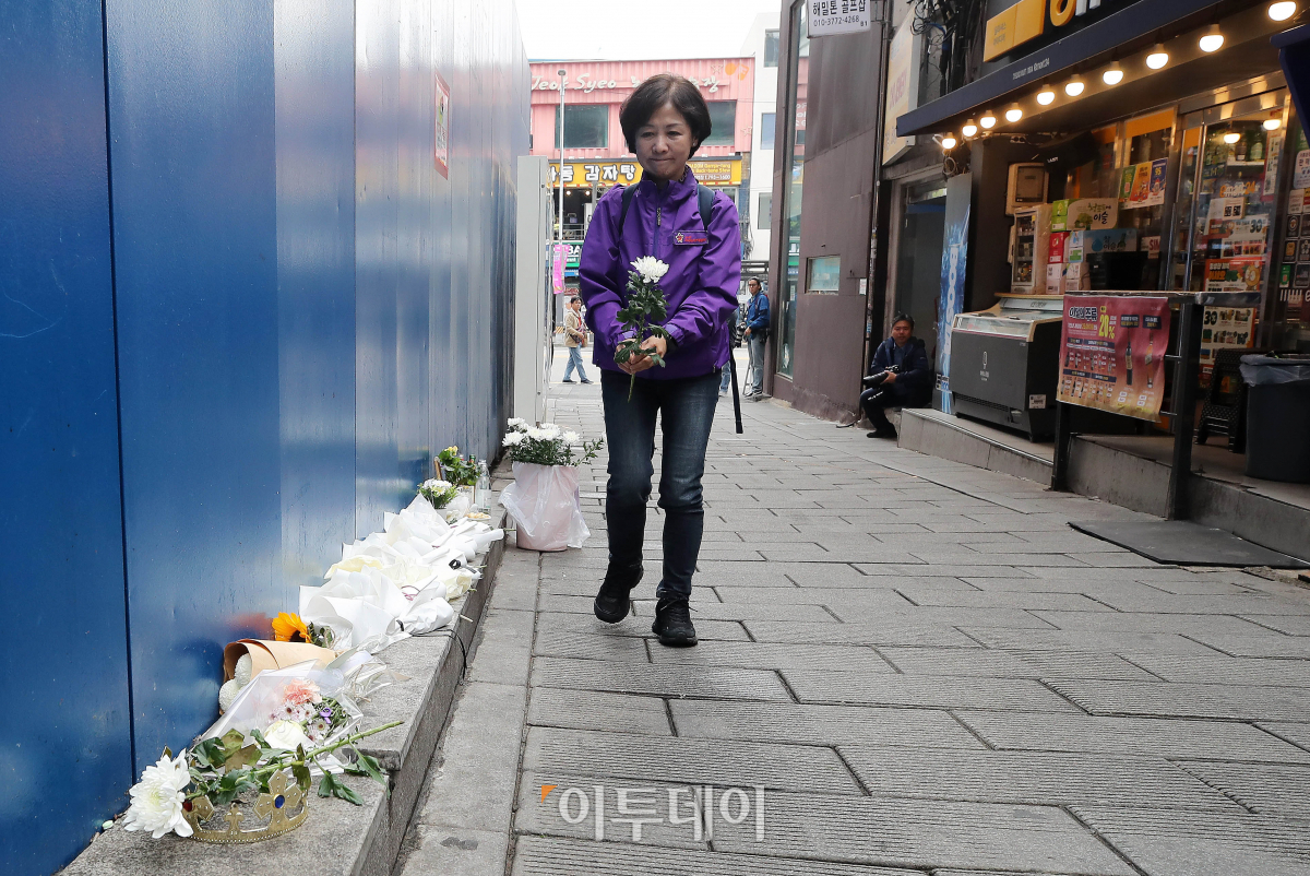 ▲28일 서울 용산구 이태원 참사 골목 '10.29 기억과 안전의길'에서 열린 새로운 10·29 이태원 참사 기억과 안전의 길 2주기 빌보드 개막식을 마친 한 유가족이 헌화를 하고 있다. 조현호 기자 hyunho@
