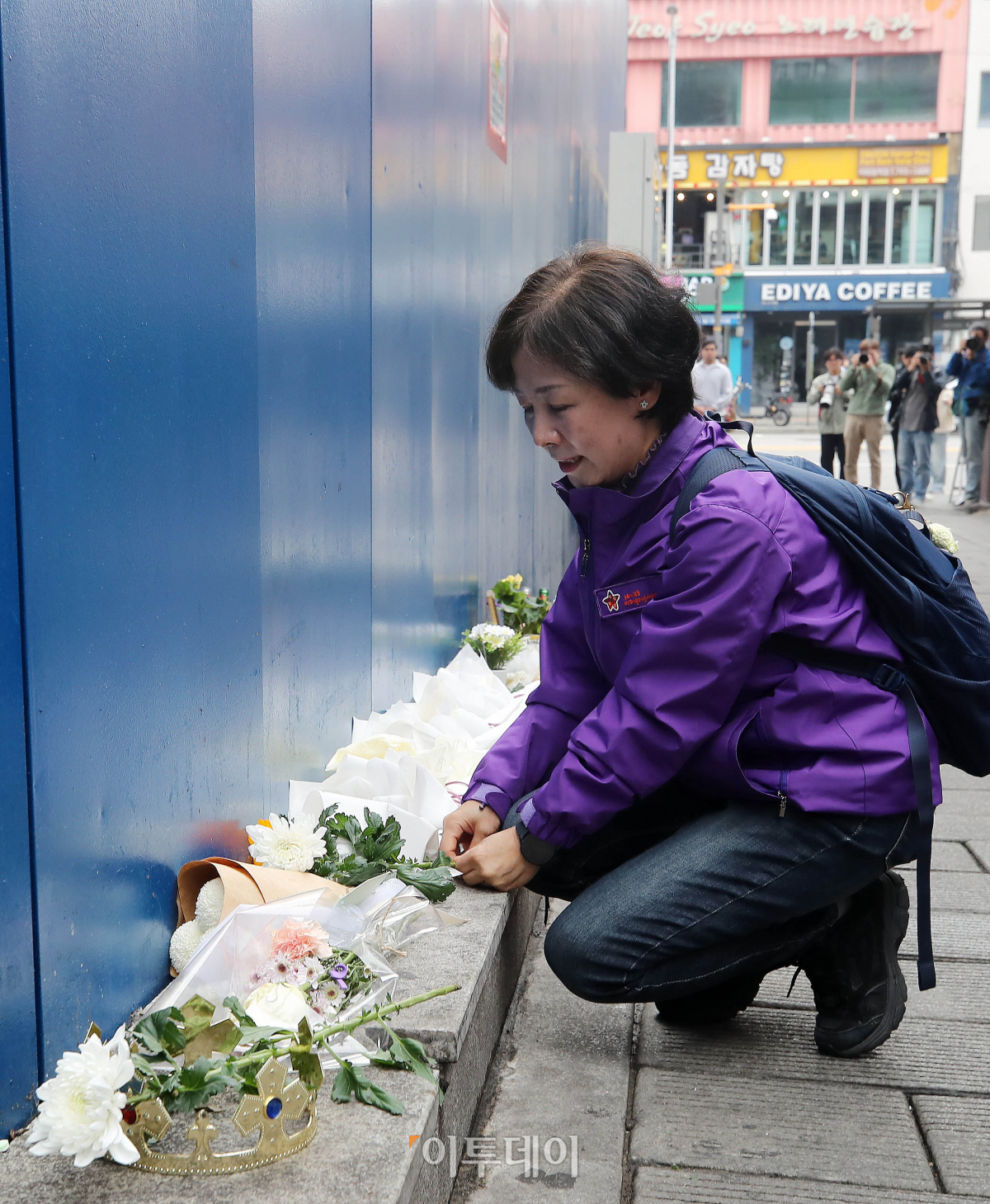 ▲28일 서울 용산구 이태원 참사 골목 '10.29 기억과 안전의길'에서 열린 새로운 10·29 이태원 참사 기억과 안전의 길 2주기 빌보드 개막식을 마친 한 유가족이 헌화를 하고 있다. 조현호 기자 hyunho@