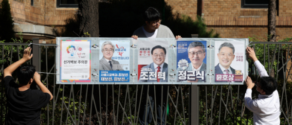 ▲10.16 서울시교육감 보궐선거의 공식 선거운동이 시작된 3일 오전 서울 종로구 대학로에서 선관위 관계자가 선거벽보를 부착하고 있다. (뉴시스)