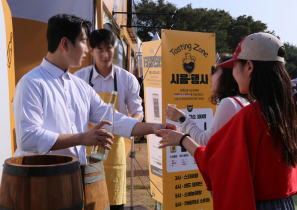 ▲방문객들이 12일 토요일 오후 이마트 '와인장터' 부스에서 와인을 시음하고 있다. (사진제공=이마트)