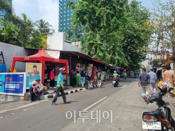 ▲지난달 25일 인도네시아 하나은행 법인과 IBK기업은행 법인 건물 사이 도로 한 쪽에 길게 늘어선 노점상에서는 BRI(Bank Rakyat Indonesia)의 모바일 애플리케이션(앱)인 ‘BRImo’로 결제를 하면된다고 홍보하고 있었다. BRI는 1895년 설립된 자산규모 2위 은행으로, 인도네시아 정부가 53%의 지분을 보유한 국영은행이다. (유하영 기자 haha@)