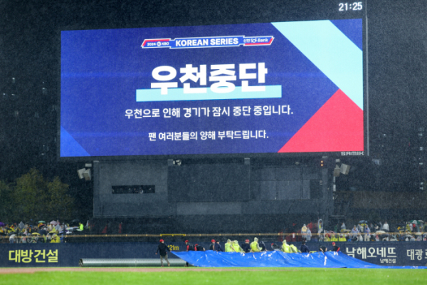 ▲21일 광주 기아챔피언스필드에서 열린 2024 신한 SOL뱅크 KBO 포스트시즌 한국시리즈 1차전 삼성 라이온즈와 KIA 타이거즈의 경기. 6회초 강한 비로 경기가 잠시 중단되자 경기장 관계자들이 방수포를 경기장에 덮고 있다.  (연합뉴스)