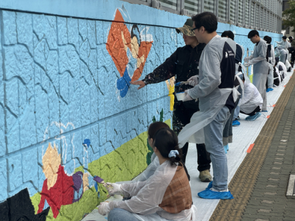 ▲폴라리스오피스그룹 계열사 임직원들이 서울 구로구 관내 초등학교에 벽화 그리기 봉사활동을 하고 있다.  (사진제공=폴라리스오피스그룹)