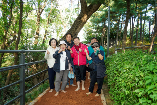 ▲답십리근린공원 숲속 황톳길에서 주민들과 기념사진 촬영하는 이필형 동대문구청장(가운데). (사진제공=동대문구)