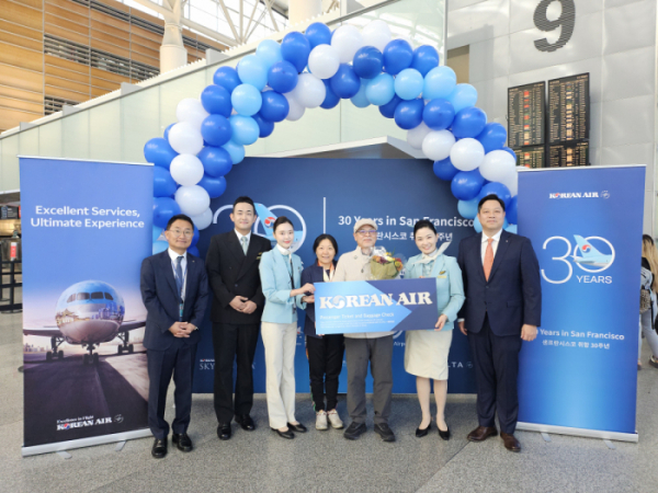 ▲대한항공은 29일(현지시간) 미국 샌프란시스코 국제공항에서 취항 30주년 ‘탑승객 대상 기념행사’를 열었다. 인천행 대한항공 KE024편 30번째 탑승수속 승객 이하영씨가 샌프란시스코-인천 왕복 이코노미 항공권 1매를 전달받고 대한항공 관계자들과 기념사진을 촬영하는 모습. (사진제공=대한항공)