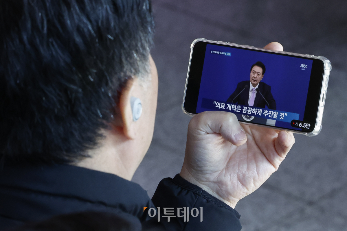 ▲7일 서울 용산구 서울역 대합실에서 한 시민이 스마트폰으로 생중계되는 윤석열 대통령의 대국민 담화문 발표 및 기자회견을 시청하고 있다. 조현호 기자 hyunho@