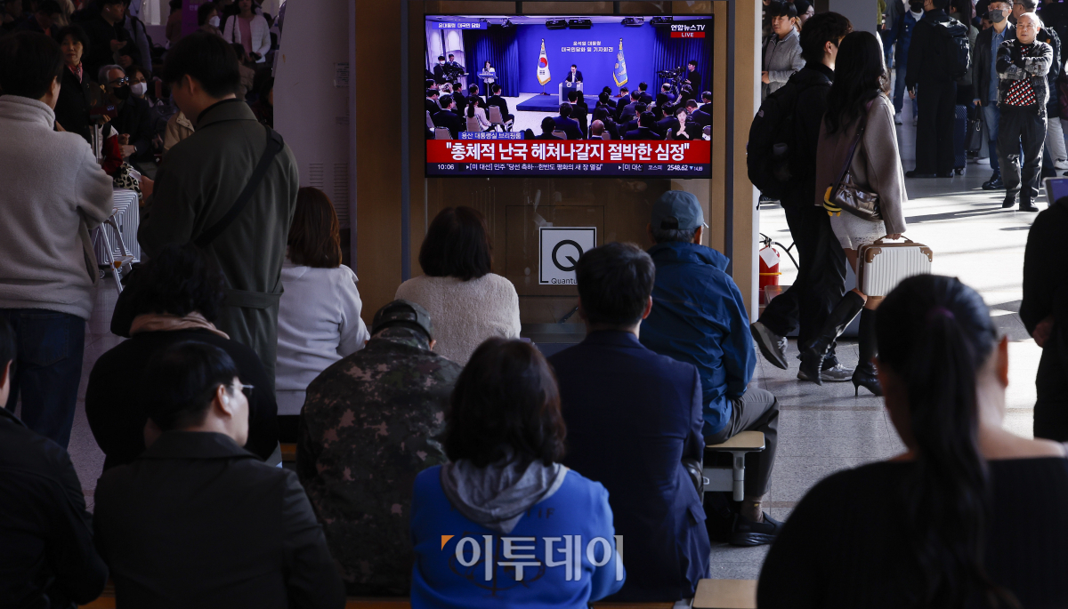 ▲7일 서울 용산구 서울역 대합실에서 시민들이 생중계되는 윤석열 대통령의 대국민 담화문 발표 및 기자회견을 시청하고 있다. 조현호 기자 hyunho@