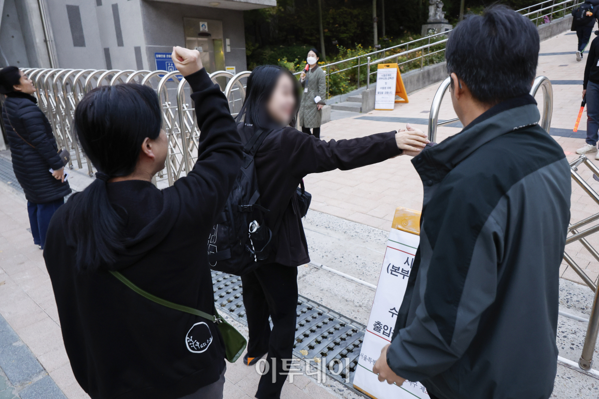 ▲2025학년도 대학수학능력시험일인 14일 서울 마포구 홍익대학교 사범대학 부속 여자고등학교에 마련된 시험장 앞에서 한 수험생 가족이 수험생을 응원하고 있다. 조현호 기자 hyunho@