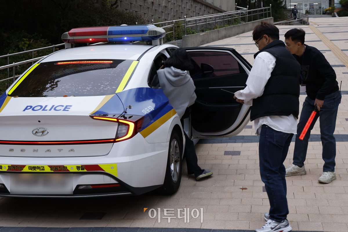 ▲2025학년도 대학수학능력시험일인 14일 서울 마포구 홍익대학교 사범대학 부속 여자고등학교에 마련된 시험장 앞에서 입실 시간 마감에 임박해 도착한 한 수험생이 경찰차를 타고 시험장으로 이동하고 있다. 조현호 기자 hyunho@