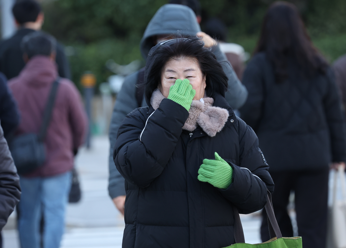 ▲아침 최저기온이 영하권으로 내려간 18일 오전 서울 종로구 광화문광장 인근에서 한 시민이 장갑을 끼고 이동하고 있다. (연합뉴스)
