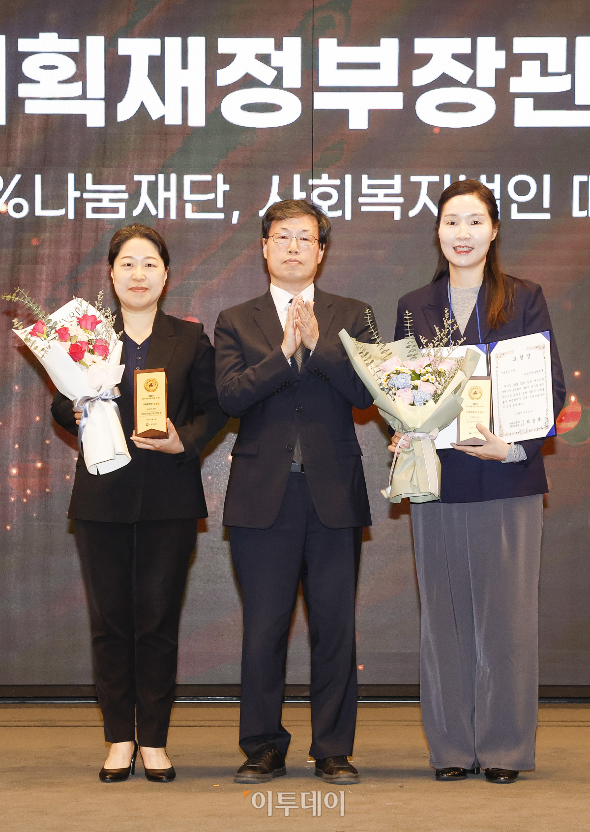 ▲21일 서울 영등포구 중소기업중앙회에서 열린 '2024 CSR 필름 페스티벌 어워드’에서 정명화(오른쪽) 포스코1%나눔재단 리더와 안연진 사회복지법인 따뜻한 동행 본부장이 신재식(가운데) 기획재정부 정책조정기획관에게 기획재정부 장관상 상생협력 부문을 수상한 뒤 기념촬영을 하고 있다. 경제신문 이투데이가 주최한 이 행사는 한 해 동안 사회적 가치 창출을 위한 CSR 활동 발자취를 공모하고 그 업적을 격려하기 위해 마련된 자리로 2012년 첫걸음을 내디뎌 올해로 13회째를 맞이했다. 조현호 기자 hyunho@