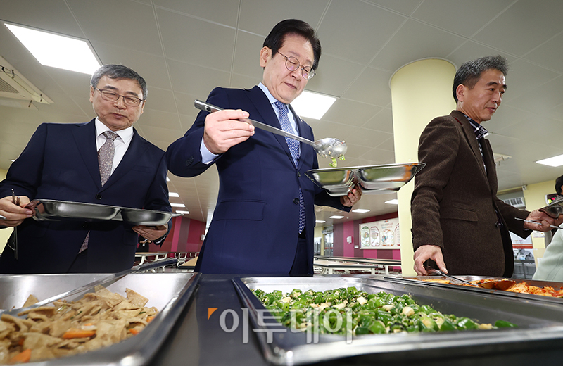 ▲이재명 더불어민주당 대표가 27일 서울 성동구 금호고에서 열린 고교 무상교육을 위한 현장 간담회를 마치고 식생활 교육실에서 배식을 받고 있다. 왼쪽은 정근식 서울시교육감. 국회사진취재단