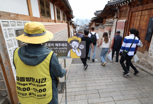 ▲몰려드는 관광객에 몸살을 앓고 있는 서울 종로구 북촌한옥마을 일부 지역에 관광객 방문시간제한이 시행된 1일 북촌한옥마을에서 관계자가 계도활동을 하고있다. 관광객들은 이날부터 오후 5시~다음날 오전 10시까지 주거용 한옥마을이 밀집된 '레드존'에 드나들 수 없다. 주민들이 불편을 호소하자 종로구청은 7월 북촌을 특별관리지역으로 지정했다. 주민 불편 수준에 따라 레드존, 옐로우존, 오렌지존을 나눴는데 이중 레드존은 북촌로 11길 일대로 가장 많은 관광객이 찾는 주거용 한옥 밀집 지역이다. 구는 시행 초기 혼란을 막기 위해 내년 2월까지 시범적으로 관광객 방문 시간을 통제한다. 본격적인 단속이 이뤄지는 내년 3월부터는 통행 시간을 어길 경우, 과태료 10만원도 부과된다. 신태현 기자 holjjak@