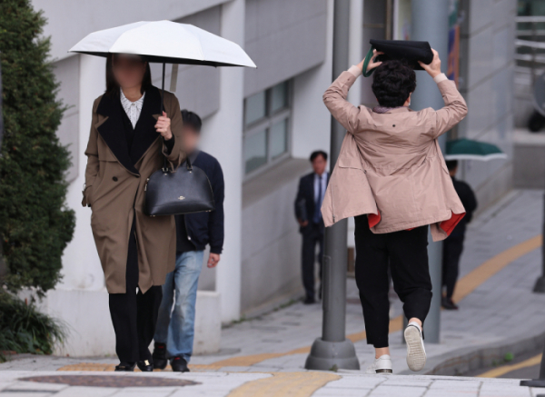 ▲흐린 날씨를 보인 6일 오전 서울 시내 한 대학병원에서 비가 내리자 한 시민이 가방으로 머리를 가리고 뛰고 있다. (연합뉴스)