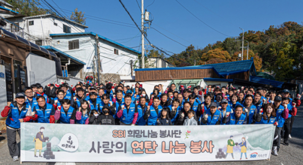 ▲SBI저축은행 임직원이 2일 소외 이웃 지원을 위한 연탄 나눔 봉사활동 중 기념 사진을 촬영하고 있다. (사진제공=SBI저축은행)