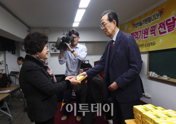 ▲이선재(오른쪽) 일성여자중고등학교 교장이 12일 오후 서울 마포구 일성여자중고등학교에서 열린 수능시험 합격 기원 떡 전달식에서 일성여자고등학교 수능 최고령 응시자 임태수 씨(83세)에게 수능 합격 기원 떡을 전달하고 있다. 조현호 기자 hyunho@