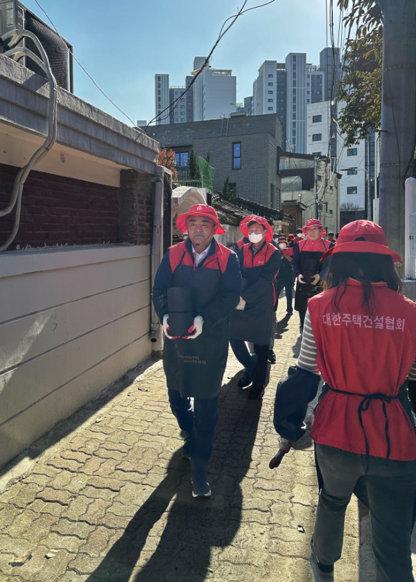 ▲정원주 대한주택건설협회장이 사랑의 연탄나눔 봉사활동을 하고 있다. (사진제공=대한주택건설협회)