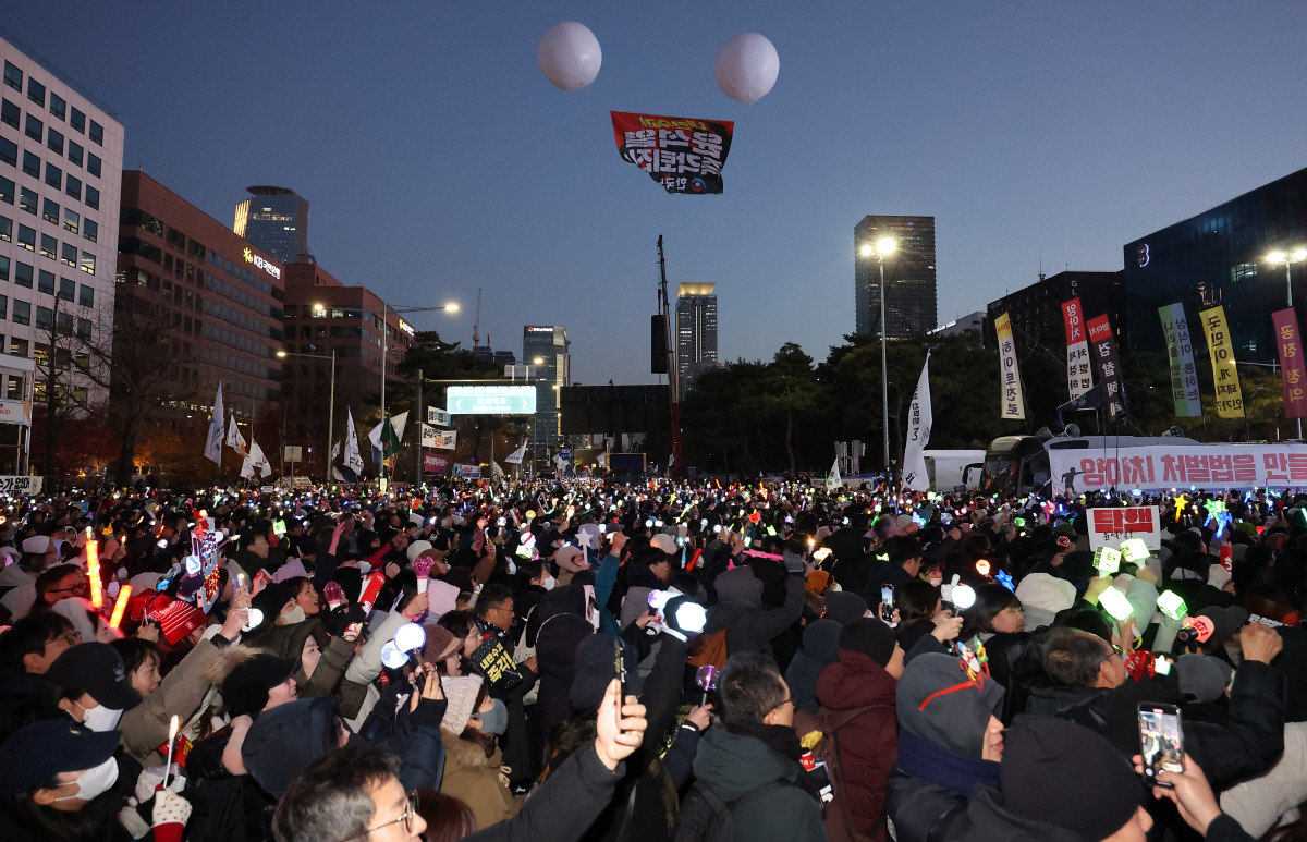 ▲윤석열 대통령 탄핵소추안이 통과된 2024년 12월 14일 서울 여의도 국회 앞에서 ‘윤석열 즉각 퇴진·사회대개혁 비상행동’ 주최로 열린 촛불집회에 참석한 시민들이 환호하고 있다.  (연합뉴스)