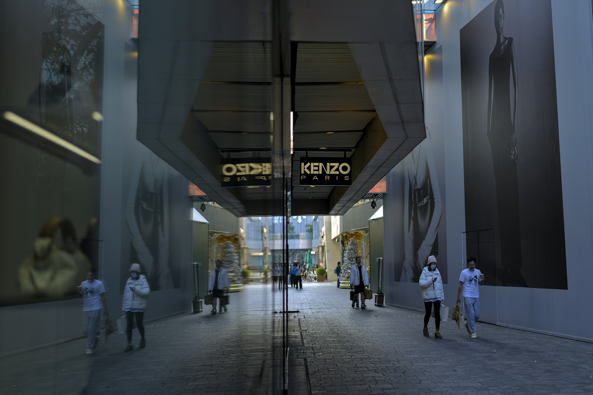 ▲중국 베이징 쇼핑몰에서 쇼핑객들이 구매한 상품을 들고 지나가고 있다. AP연합뉴스