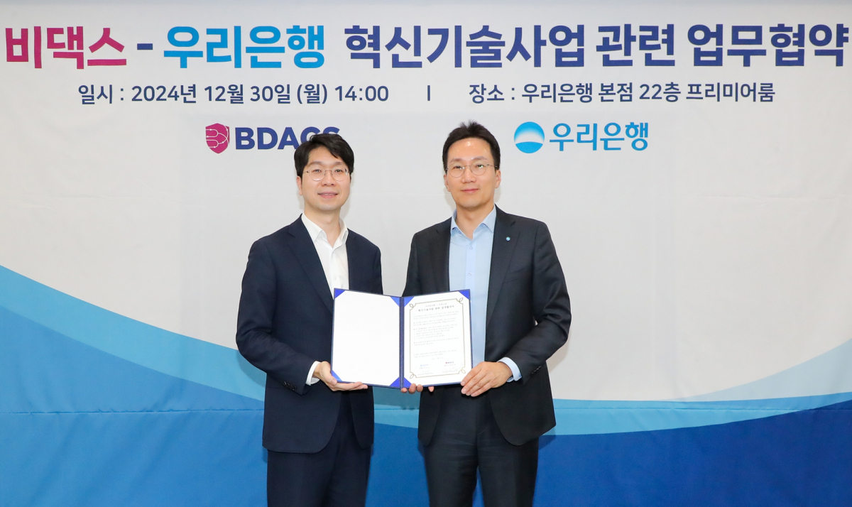 ▲우리은행이 30일 은행 본점에서 비댁스와 혁신기술사업 관련 업무협약(MOU) 체결 후 사진 왼쪽부터 류홍열 비댁스 대표, 옥일진 우리은행 디지털전략그룹장이 기념촬영을 하고 있다.  (사진제공=우리은행)