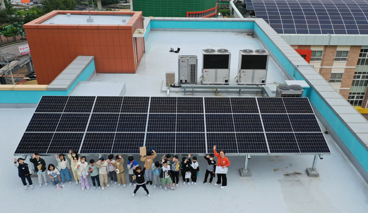 ▲거제 상동초등학교 학생들이 ‘맑은학교 만들기’를 통해 건물 옥상에 설치된 태양광 설비를 살펴복고 있다. (사진제공=한화그룹 )