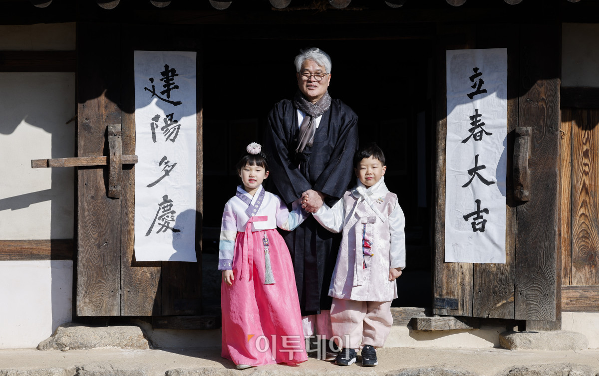 ▲절기상 봄이 시작된다는 입춘인 3일 서울 종로구 국립민속박물관 오촌댁에서 열린 입춘 세시행사에서 송현수 서예가와 아이들이 대문에 '입춘대길 건양다경' 입춘첩을 붙인 후 기념촬영을 하고 있다. 조현호 기자 hyunho@