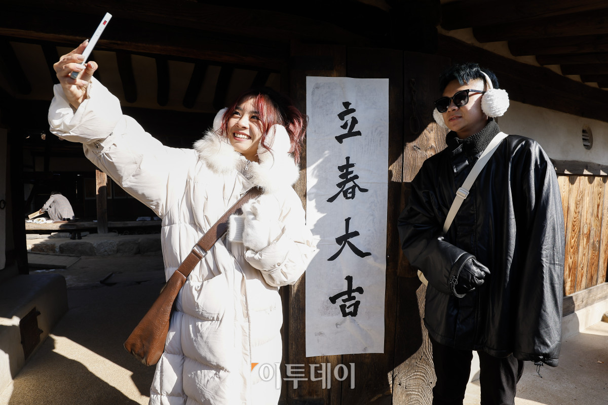 ▲절기상 봄이 시작된다는 입춘인 3일 서울 종로구 국립민속박물관 오촌댁에서 외국인 관광객들이 '입춘대길' 입춘첩이 붙은 대문 앞에서 셀카를 찍고 있다. 조현호 기자 hyunho@